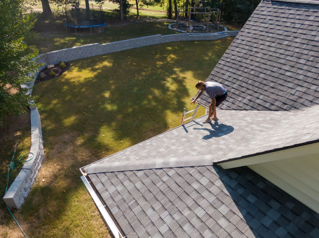 a worker is installing a malarkey roofing.