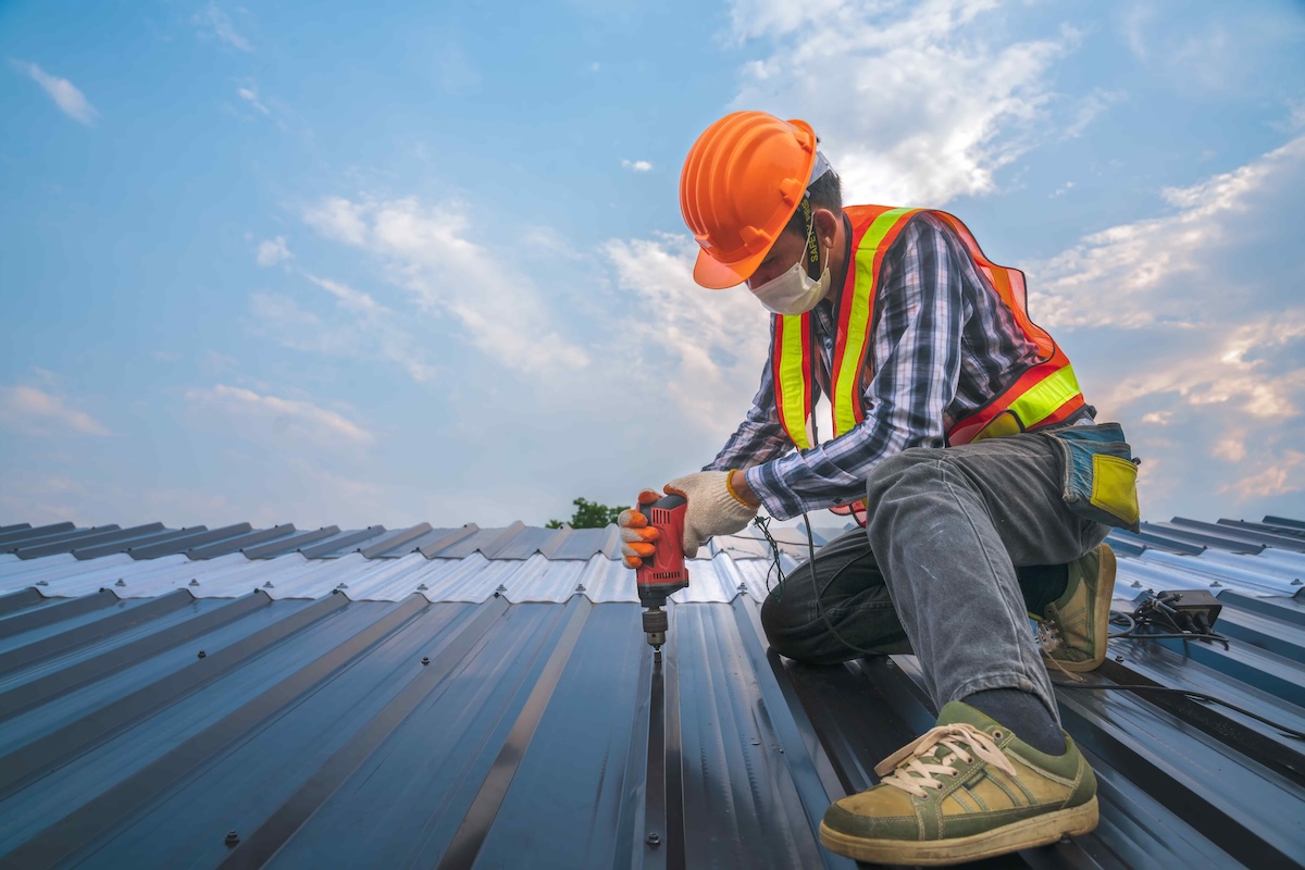 Expertise construction worker wear safety uniform install new metal roofing work for roof ,worker roofer builder working on roof structure on construction site, industrial concept with copy space