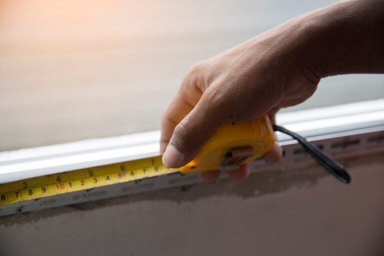 closeup of hand workers are using tape measure the window in construction site.