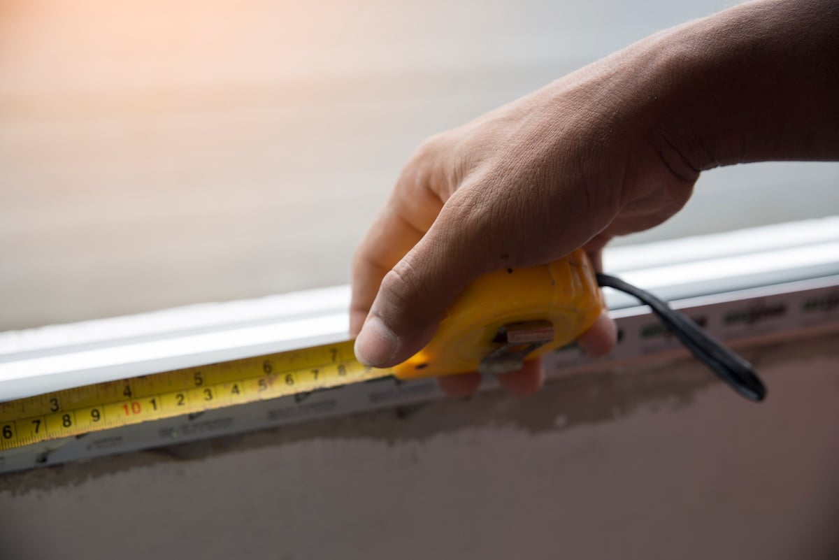 closeup of hand workers are using tape measure the window in construction site.
